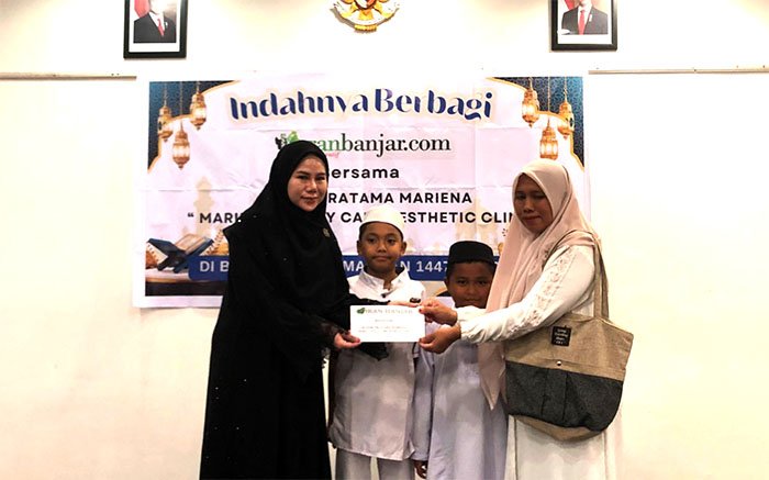 Owner Klinik Pratama Mariena (kiri) menyerahkan donasi kepada pengasuh anak yatim.